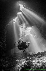 Cathedral lighting illuminates diver inside a cave at St ... by Gabriel De Leon Jr 
